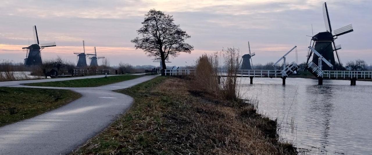 Explore the picturesque windmills of Kinderdijk during sunset, capturing Dutch heritage and serene landscapes.