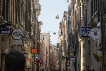 Explore a vibrant Amsterdam street showcasing historic buildings and lively city life, perfect for travel enthusiasts.