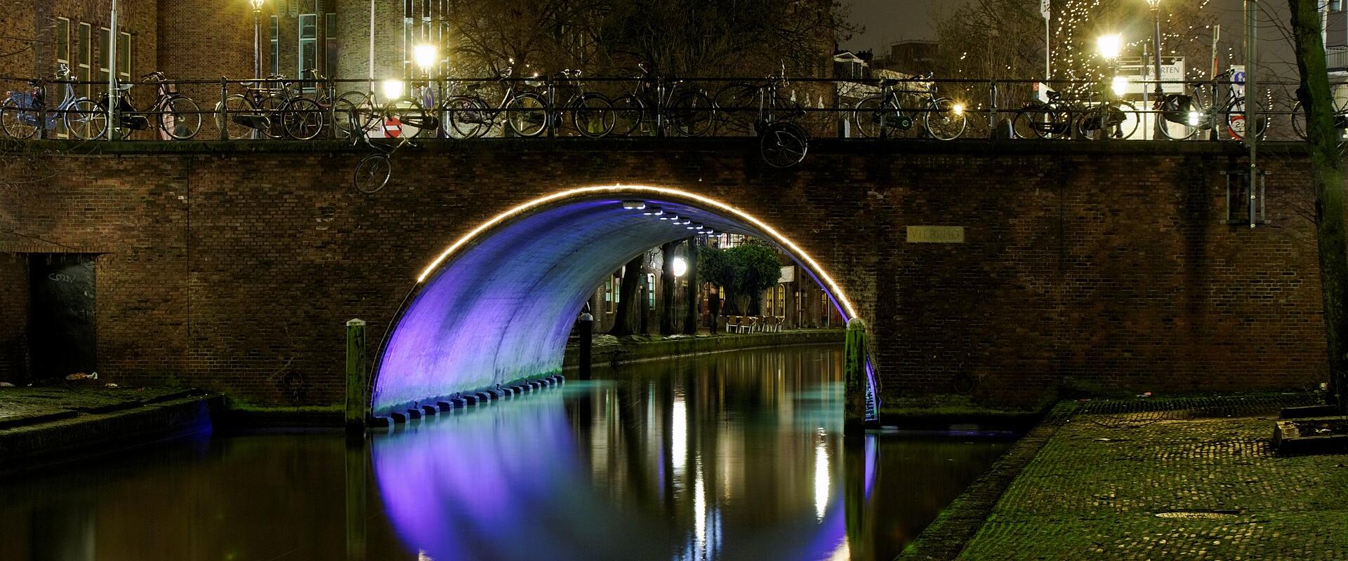 Illuminated canal bridge in Utrecht at night