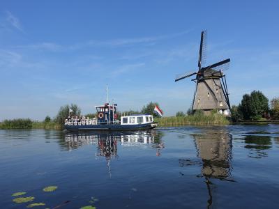 A tour boat passing a windmill on the Kinderdijk canals