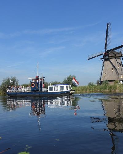 A tour boat passing a windmill on the Kinderdijk canals