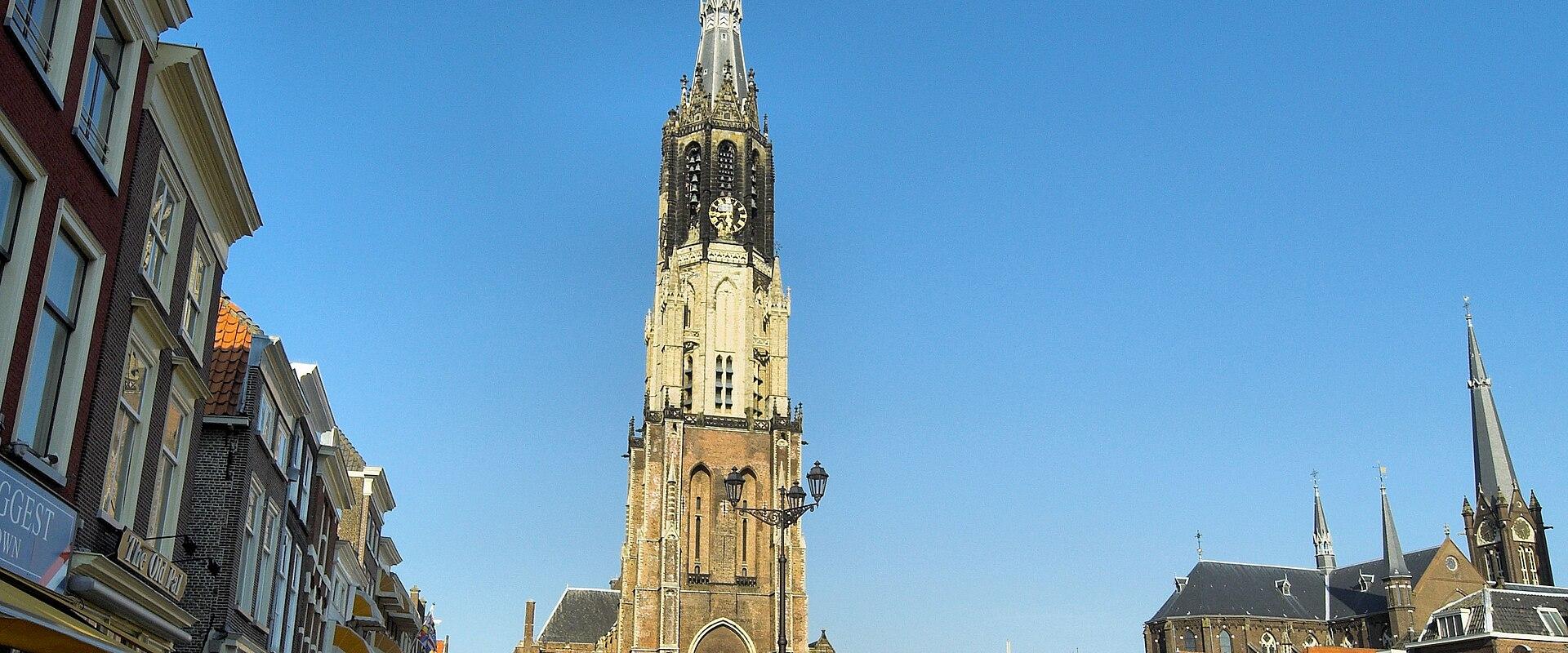 The Markt and the Nieuwe Kerk tower in Delft under a blue sky