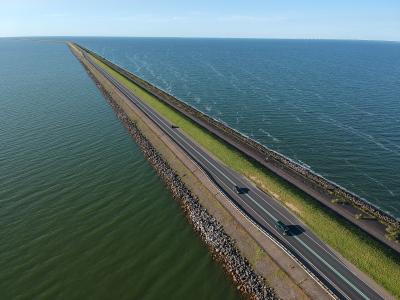 A long dike road running straight across the water of the Markermeer