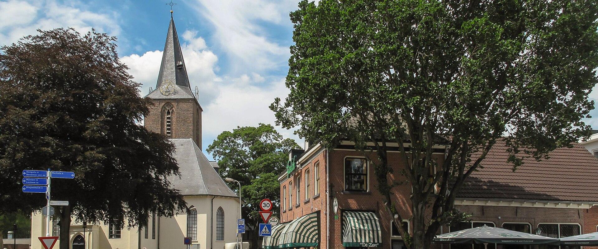 A village street and church tower in Hof van Twente
