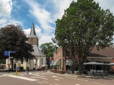 A village street and church tower in Hof van Twente