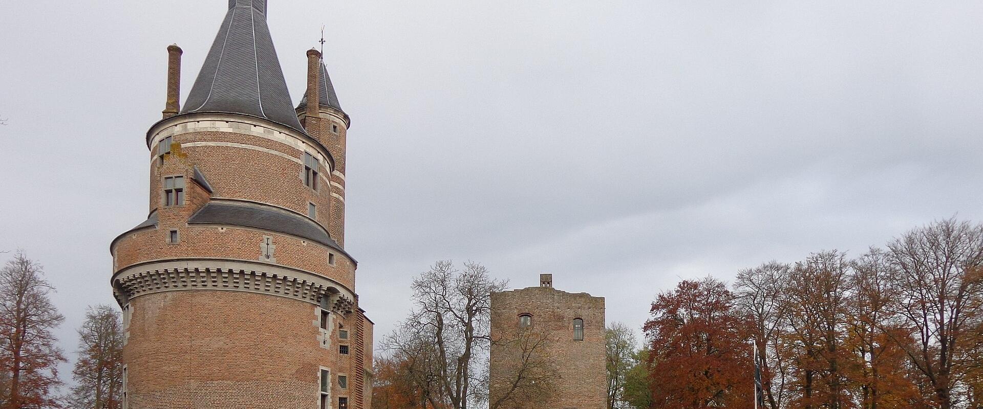 The round red-brick tower of Kasteel Duurstede in Wijk bij Duurstede, Netherlands, rising above the castle moat among autumn trees