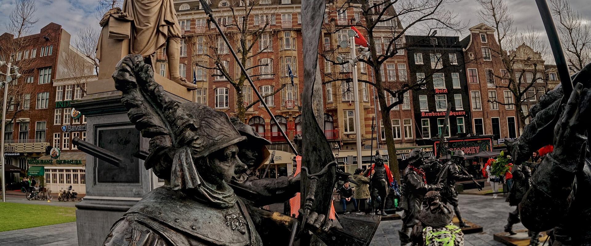 The Night Watch sculptures facing Rembrandt's statue on Rembrandtplein